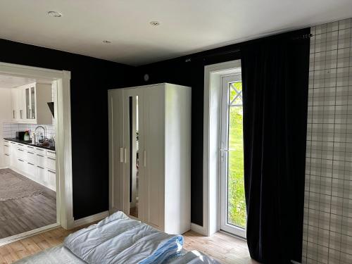 a bedroom with black walls and a bed and a window at Sörbyvägen 6 in Floby