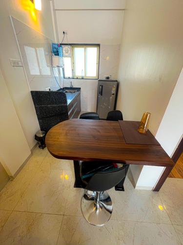 a kitchen with a wooden table and some chairs at Pushpam Sanskruti Resort Karjat- Pure Veg in Karjat