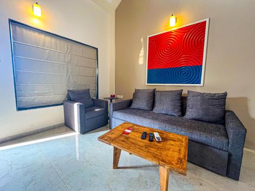 a living room with a couch and a coffee table at Pushpam Sanskruti Resort Karjat- Pure Veg in Karjat