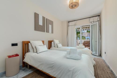 a bedroom with two beds and a window at New Renovated Front Line Beach Playa Rocio Puerto Banus in Marbella