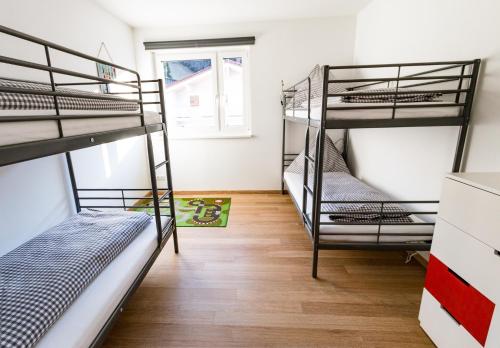 a room with three bunk beds and a window at Fleischerei - Apartments, Cafe & Weinbar in Hinterstoder