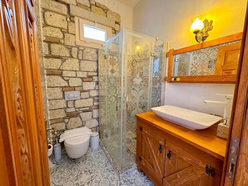 a bathroom with a shower and a toilet and a sink at The Fountain Çeşme in Çeşme