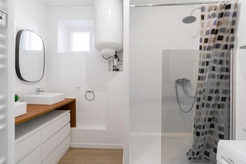 une salle de bain blanche avec une douche et un lavabo dans l'établissement Joli appartement 2 pièces proche gare St Charles, à Marseille