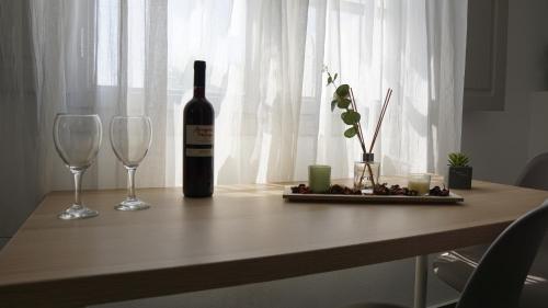 a bottle of wine and two glasses on a table at Vivian's home in Megalokhori