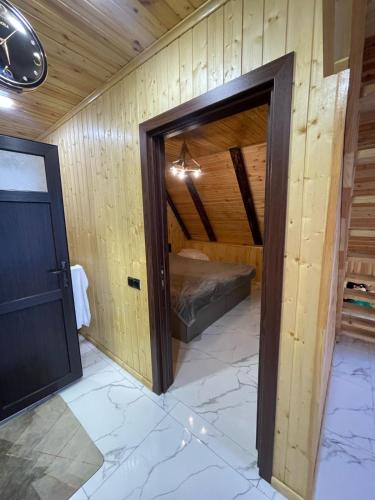 a room with a bed in a wooden wall at A Frame village in Mekhrably