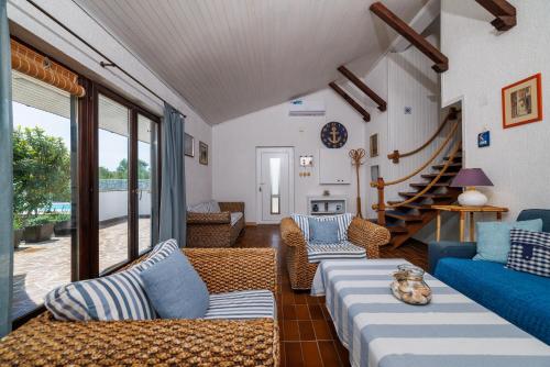 una sala de estar con muebles azules y blancos y una escalera. en VILA OLIVE TREE Krk, en Kornić