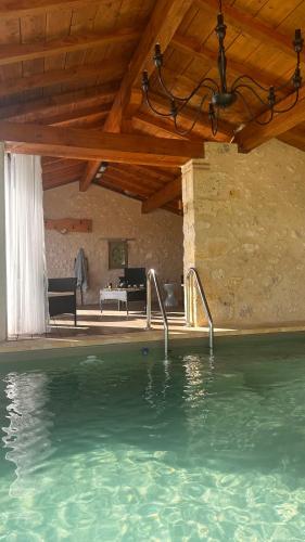 une maison avec une piscine et un plafond en bois dans l'établissement Domaine Léa Chanflaur - Spa - La maison du bonheur, à Terraube