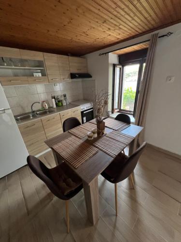 a kitchen with a wooden table and chairs in a room at Xlimos house in Ayía Kiriakí
