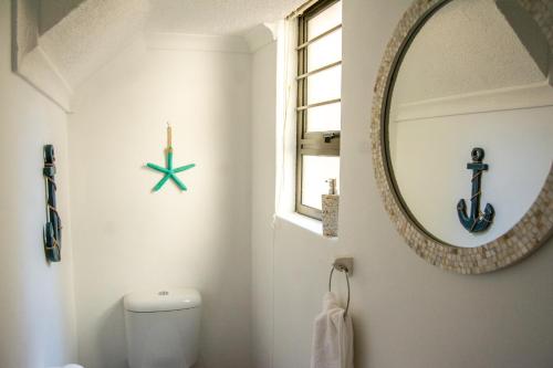 a bathroom with a mirror and a white toilet at Ocean Dream Beach Cottage in Swakopmund