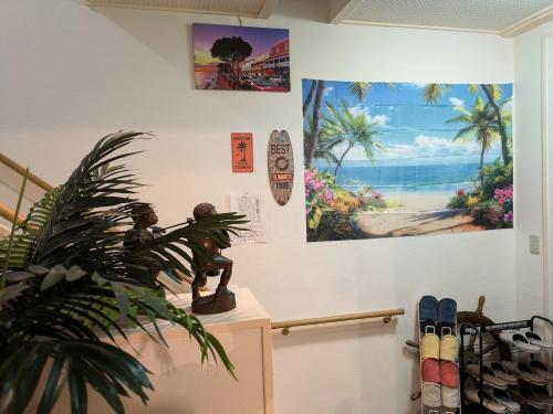 a room with a plant and a painting on the wall at kawana To the Beach in Ito