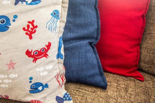 a bag and a red pillow on a couch at Ocean Dream Beach Cottage in Swakopmund