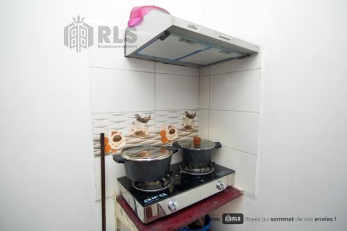 a stove with pots and pans on top of it at Résidence Le Sommet Douala in Douala