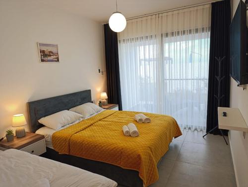 une chambre avec un lit avec deux serviettes dessus dans l'établissement Family large apartment in Bahçeli, à Aglantzia