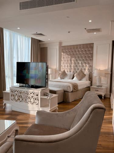 a living room with two beds and a flat screen tv at Aswar Boutique Hotel in Al Khobar