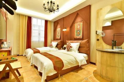 a bedroom with two beds and a chandelier at Ancient Road Yunju in Kashgar