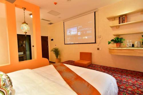 a hotel room with a bed and a projection screen at Ancient Road Yunju in Kashgar