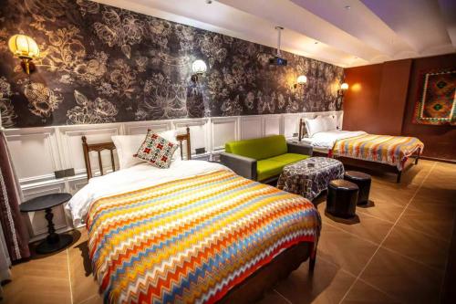 a bedroom with two beds and a green chair at Ancient Road Yunju in Kashgar