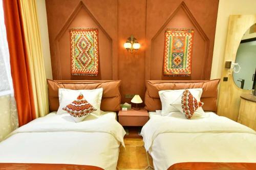 two beds sitting next to each other in a room at Ancient Road Yunju in Kashgar