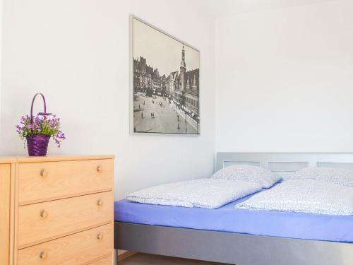 a bedroom with a bed and a picture on the wall at Ferienwohnung Leipzig Nord in Leipzig