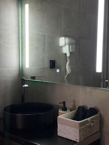 a bathroom with a bath tub and a mirror at Joannas Airport Luxury Rooms in Artemida