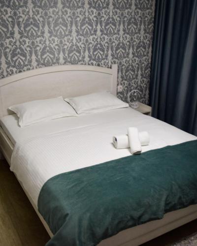 a bed with two white towels on top of it at Hotel "CONTINENT" halal in Karagandy