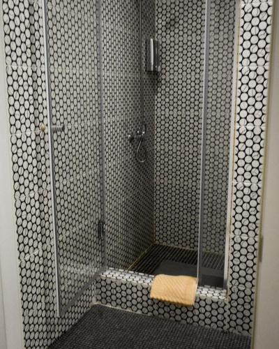 a shower with a glass shower stall with a towel at Hotel "CONTINENT" halal in Karagandy