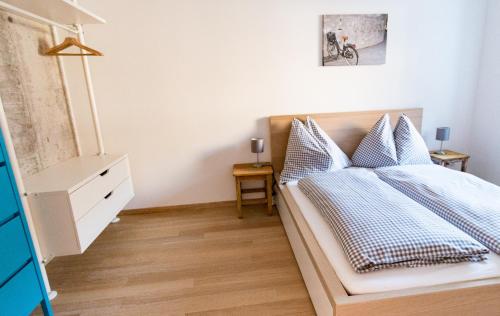 a bedroom with a bed with blue and white pillows at Fleischerei - Apartments, Cafe & Weinbar in Hinterstoder