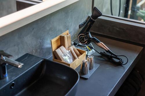 a bathroom sink with a blow dryer next to it at Nazuna Hakone Miyanosita in Miyanoshita