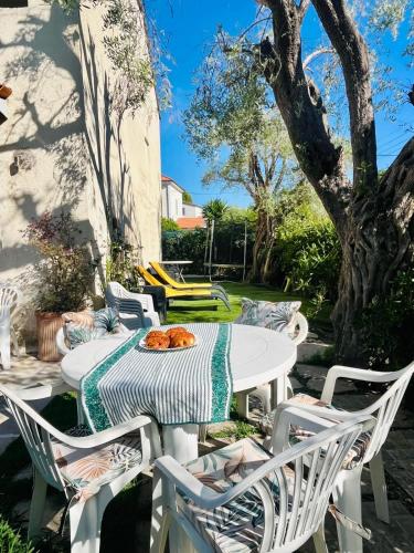une table blanche et des chaises sur une terrasse dans l'établissement Exclusive 80 sqm apartment with private garden and terrace on the Cap d Antibes, 300 mt from sandy Plage de la Salis, à Antibes