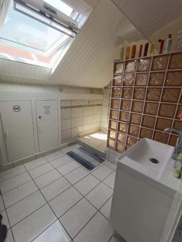 La salle de bains est pourvue d'une douche, d'un lavabo et d'une lucarne. dans l'établissement Chambre 1 simple, à Limeil-Brévannes