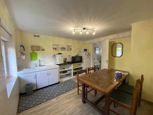 une cuisine et une salle à manger avec une table et des chaises dans l'établissement T2 centre Erquy, à Erquy