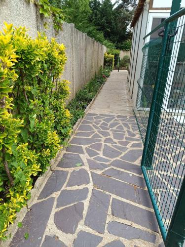 une allée en pierre à côté d'un bâtiment avec une clôture dans l'établissement Chambre 1 simple, à Limeil-Brévannes