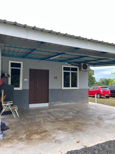 a garage with a red car parked in a parking lot at Nabilah Homestay Labuh Banting in Kepala Batas