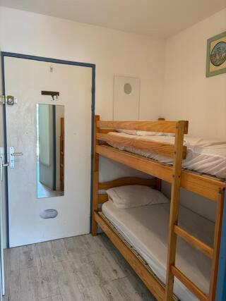 une chambre avec deux lits superposés et un miroir dans l'établissement Appartement piscine plage golf, à La Grande Motte