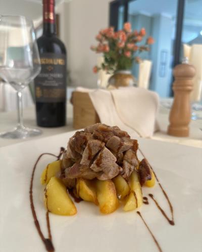 a piece of food on a table with a bottle of wine at Hotel San Francesco in San Giovanni Rotondo