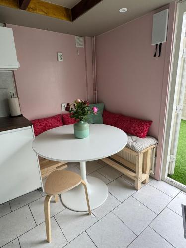 a small kitchen with a white table and a couch at Guesthouse West in Noordwijk