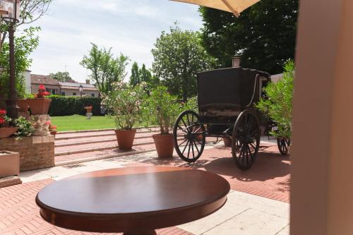 a horse drawn carriage in a yard with a table at Hotel & SPA Duchessa Isabella Collection by GSA Hotels in Ferrara