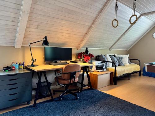a bedroom with a desk with a computer and a bed at Family home in Älmhult
