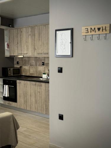 a kitchen with wooden cabinets and a white refrigerator at Joannas Airport Luxury Rooms in Artemida