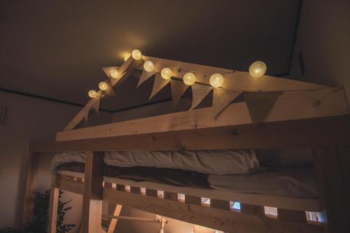 a wooden bed with lights on top of it at 北海道伊達の海辺ヴィラ 最大7名一棟貸切 ファミリー向け 北斎アート in Date