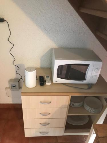 un four micro-ondes installé au-dessus d'un comptoir dans l'établissement RESIDENCE SOGNU DI MARE PLAGE Marine di Bravone, à Linguizzetta