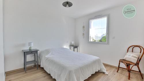 une chambre avec un lit, une chaise et une fenêtre dans l'établissement Maison familiale rue des Cordes, à Saint-Hilaire-de-Riez