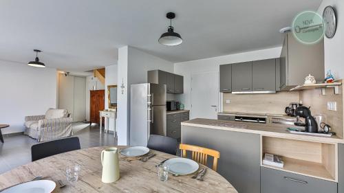 une cuisine et une salle à manger avec une table en bois dans l'établissement Maison familiale rue des Cordes, à Saint-Hilaire-de-Riez