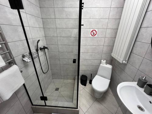 a bathroom with a shower and a toilet and a sink at FOX Hostel in Mykolaiv