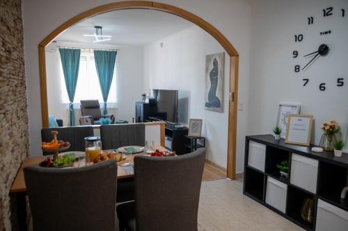 a living room with a table and a large mirror at Bella Apartman in Nyíregyháza