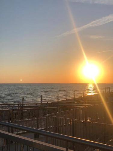 a sunset on the beach with the sun setting at La Casetta di Elena in LʼAmericano