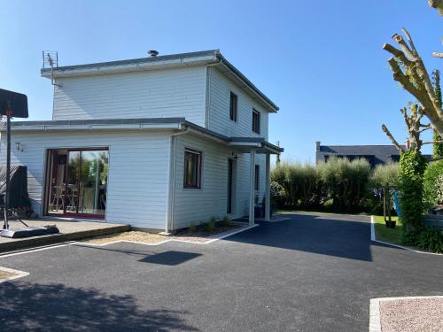 une maison blanche avec une allée devant dans l'établissement La cabane de la baie, à Plounévez-Lochrist