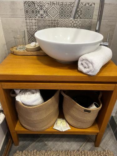 a sink and a bowl on a wooden shelf in a bathroom at Apartmán Oparno - České středohoří in Oparno