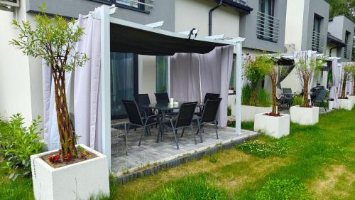 a patio with a table and chairs under a canopy at Domek Liliowe Marzenie in Chrzanów