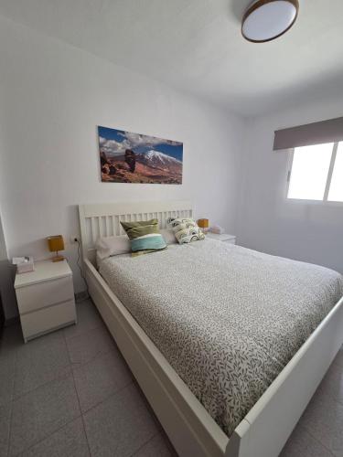una camera da letto bianca con un letto grande e una finestra di Apartamento céntrico - La Laguna a La Laguna